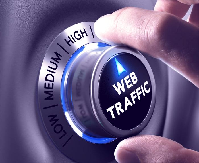 Hand turning a dial labeled web traffic from low to high